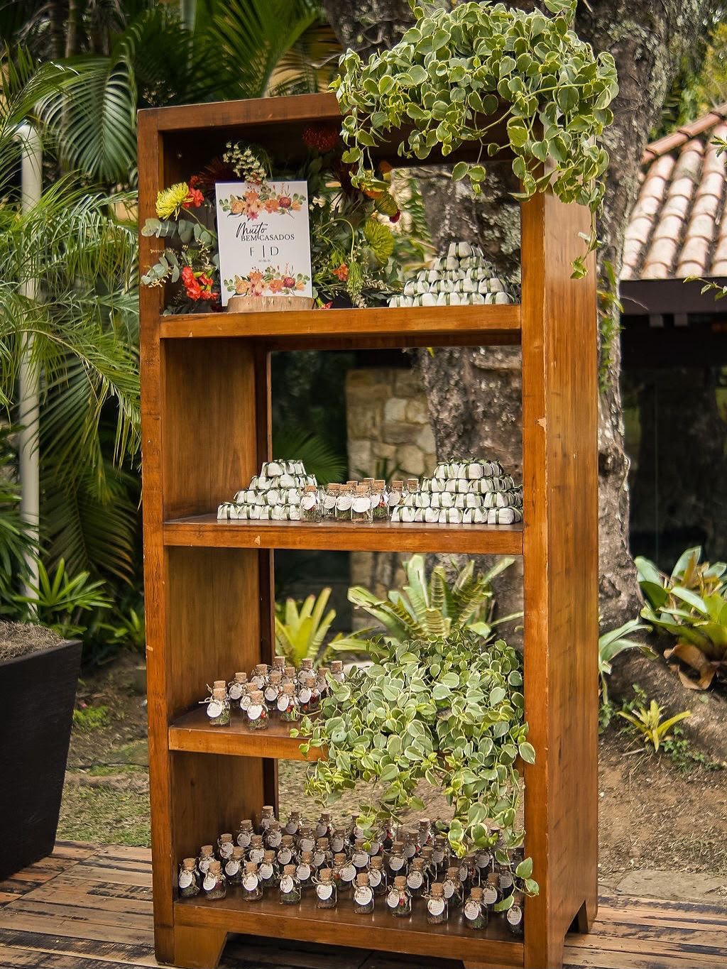 Estante de madeira com lembrancinhas e mini garrafinhas em evento